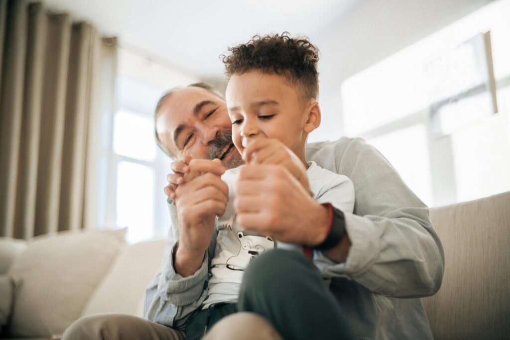 A grandfather and grandson enjoying playful quality time at home, showcasing family bonding.